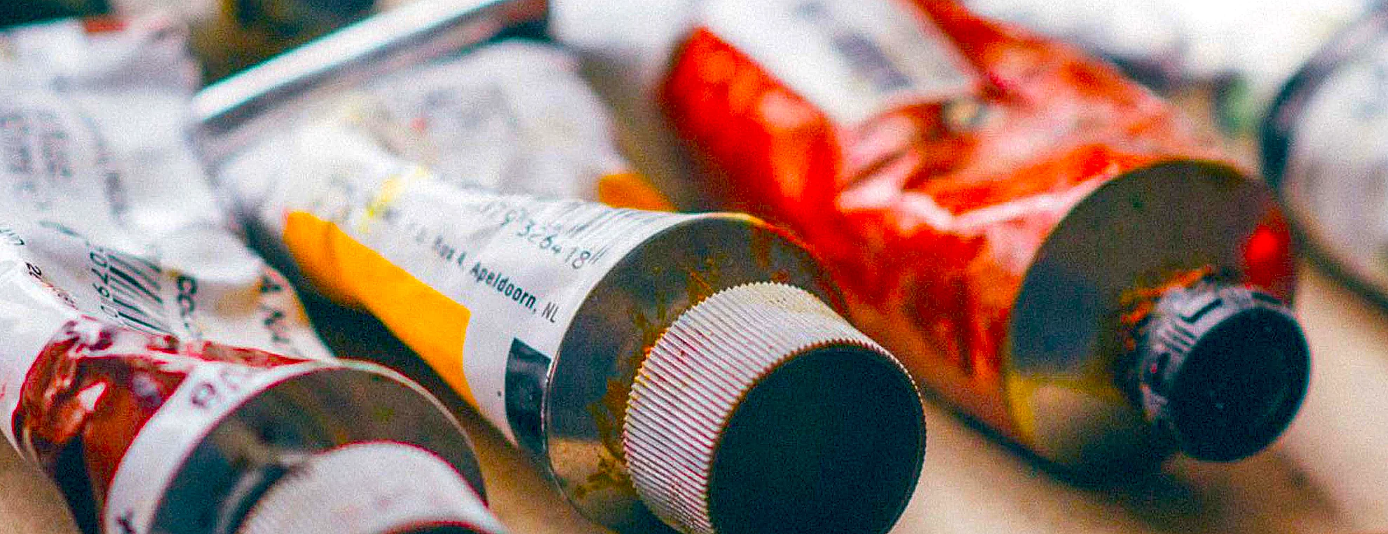 Close-up of acrylic and oil paint tubes on a studio table