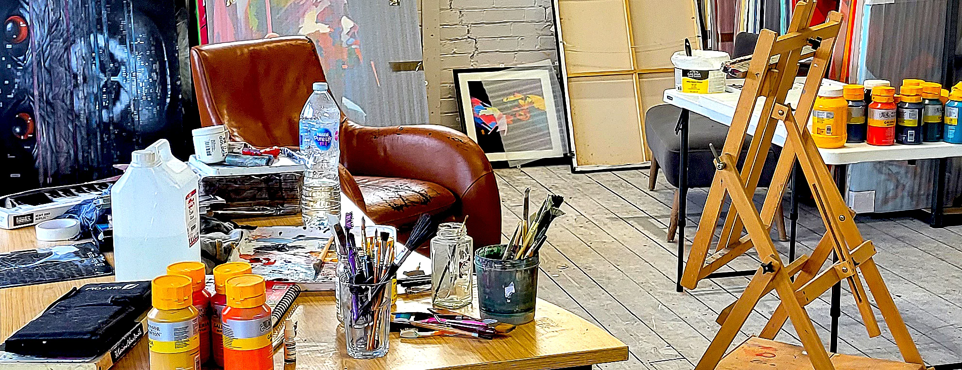 Artist studio workspace with paints, brushes and easels