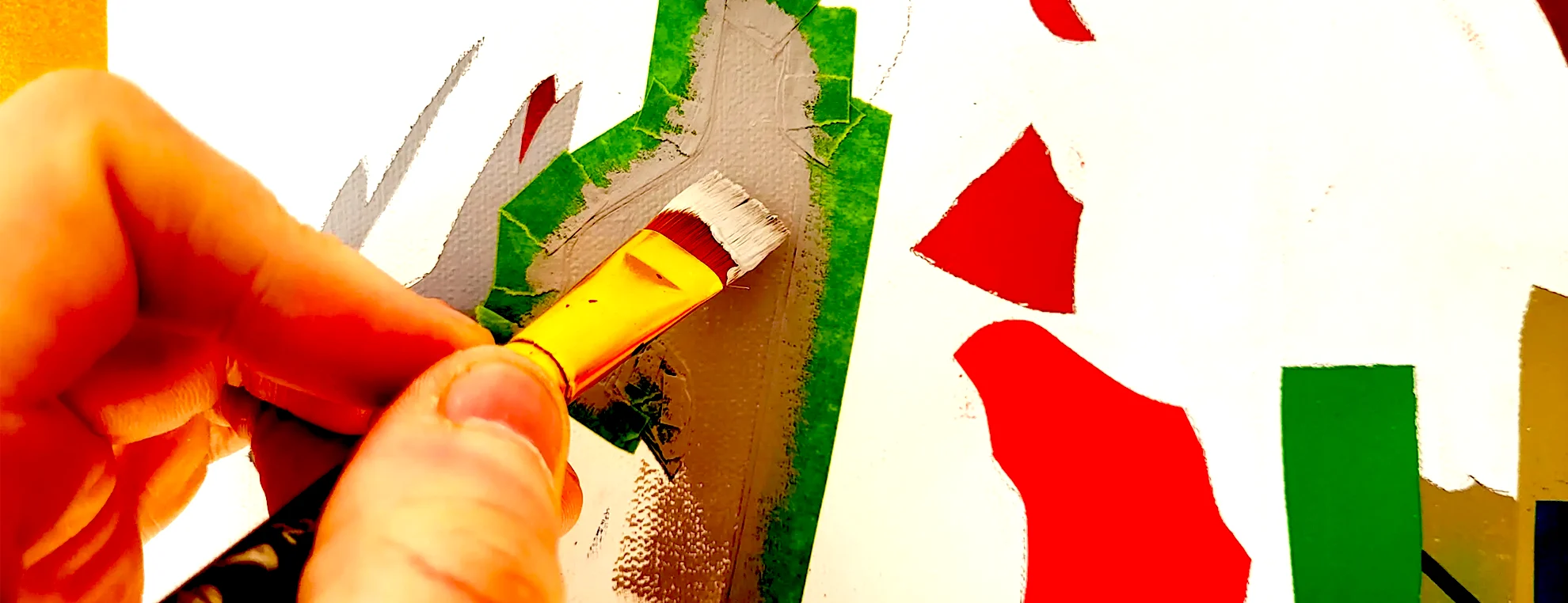 Close-up of painting process by Paul Kneen showing brush applying paint over masked surface with geometric shapes