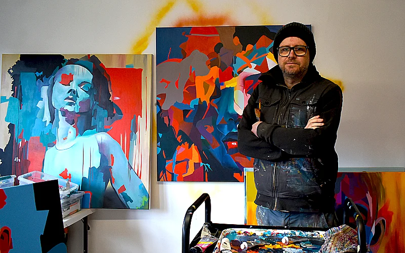 Paul Kneen in his studio with abstract portrait paintings